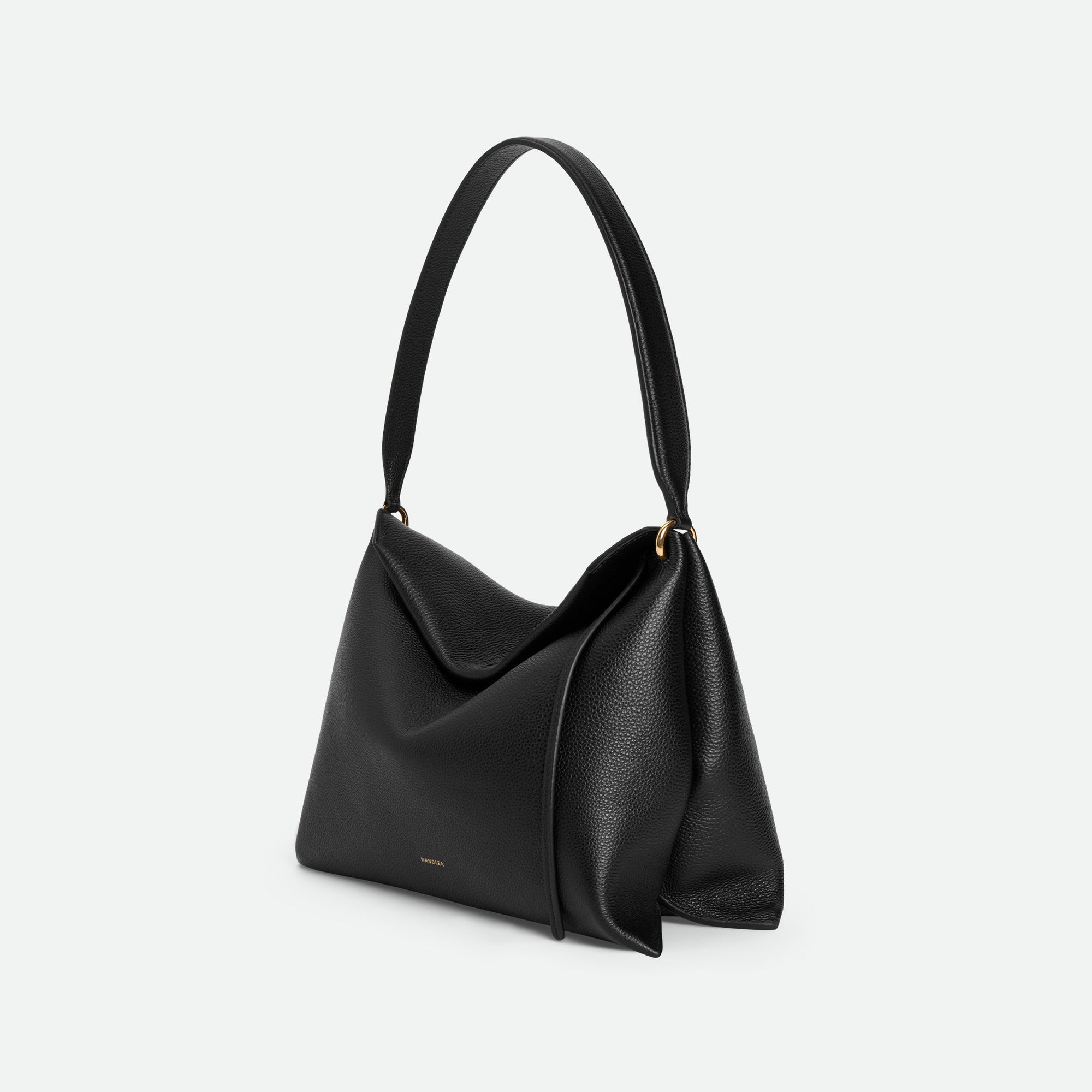 Wandler Penelope Tote Small in the color Black Crust made from calf leather with golden hardware and soft slouchy silhouette, side view.