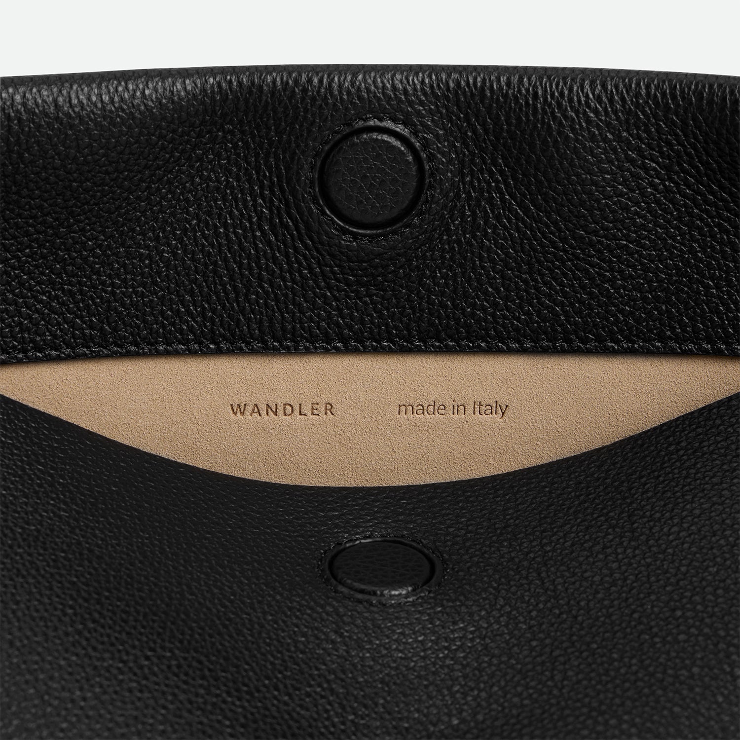 Wandler Penelope Tote Small in the color Black Crust made from calf leather with golden hardware and soft slouchy silhouette, close up detailing the closure and leather.