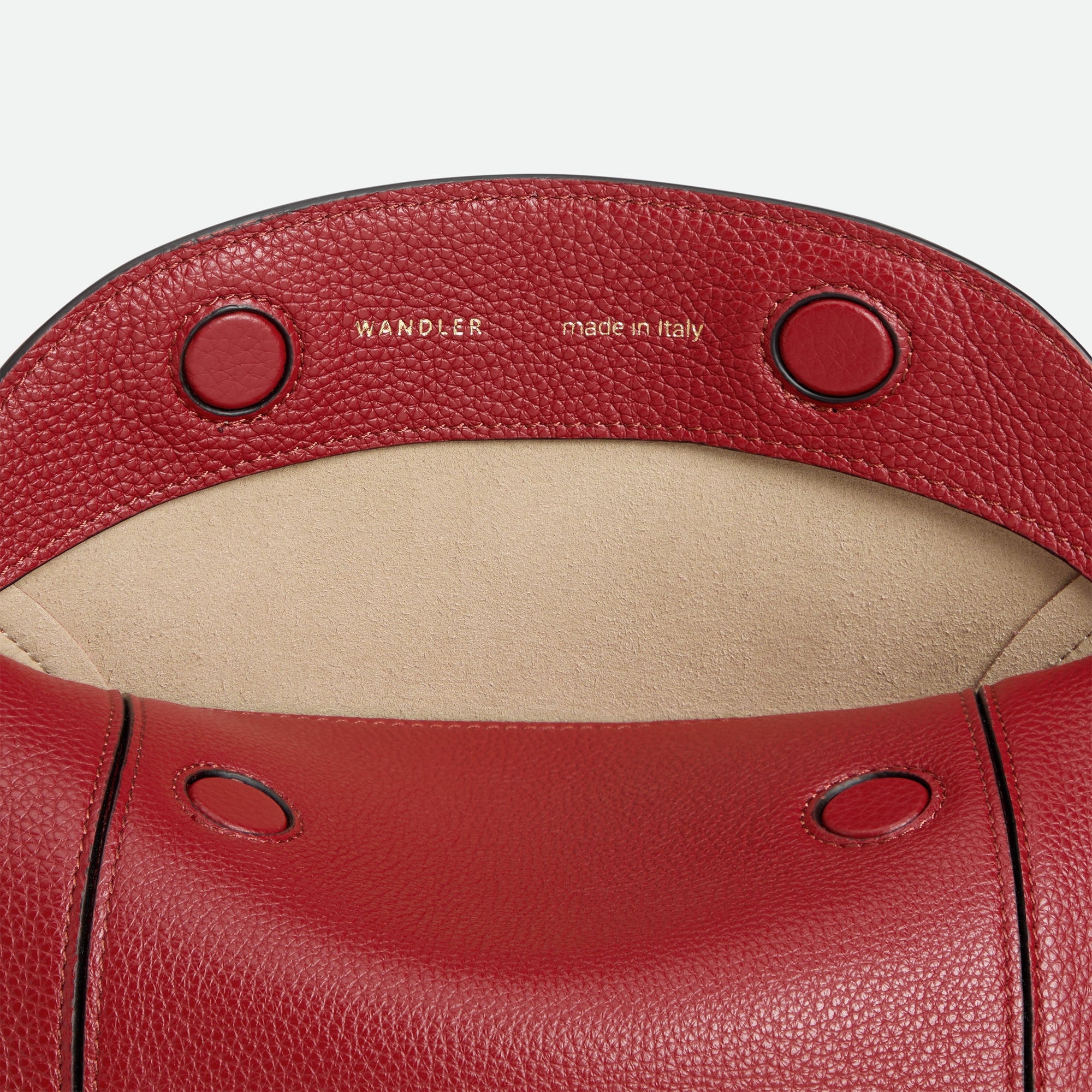 Wandler Penelope Slouch Bag in the color Scarlet Crust, made from calf leather with golden hardware and adjustable slim strap, close up detailing the closure and leather.
