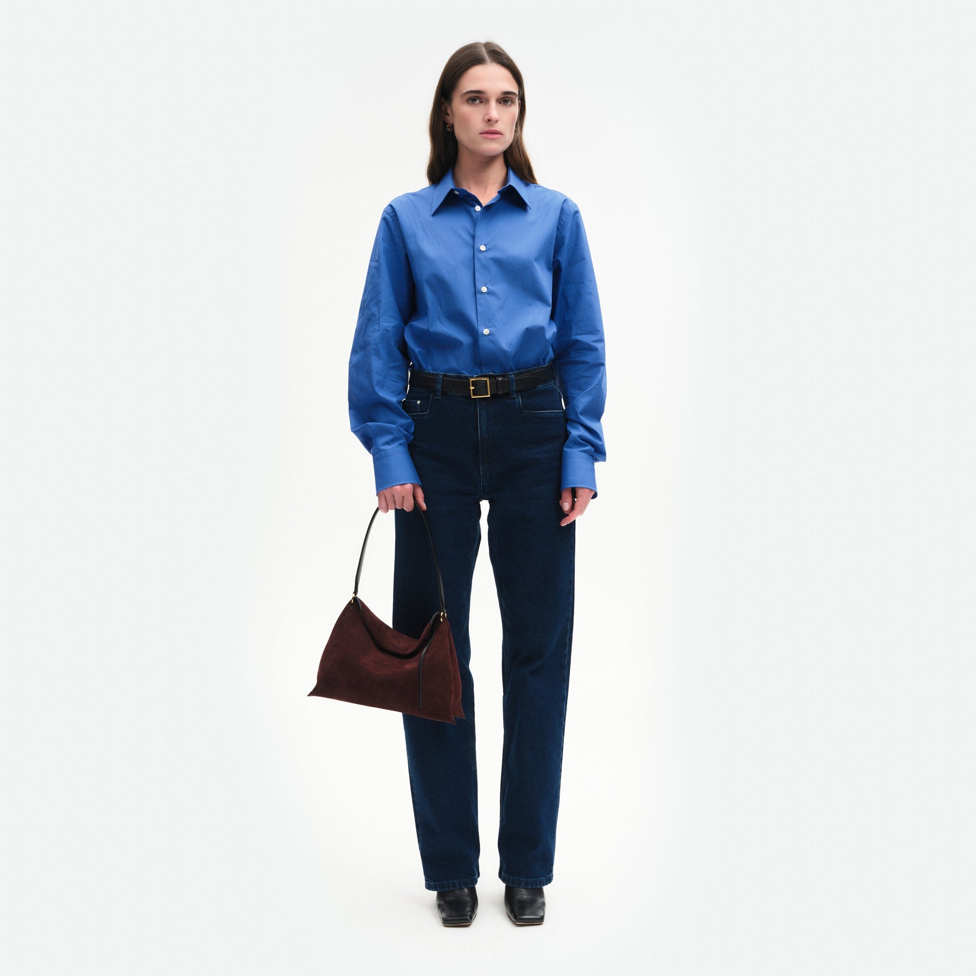 Wandler Penelope Tote Small in the color Acai Suede / Black made from calf leather with golden hardware and soft slouchy silhouette, pictured being handheld by model, full body picture.